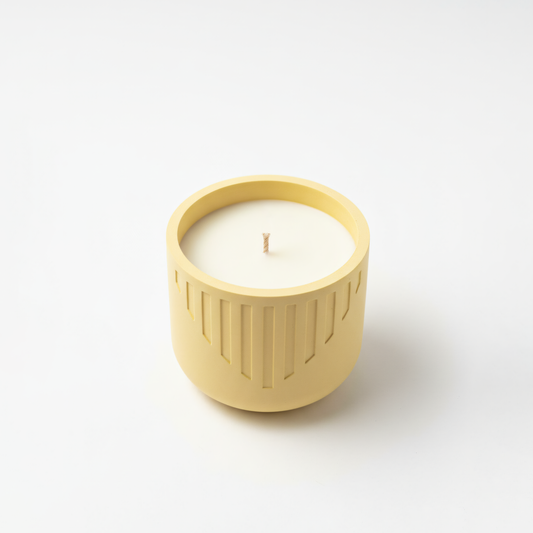 Yellow candle holder with a white candle on a light gray background